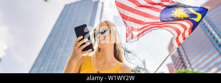 Travel und Technologie. Junge Frau Tourist mit der Flagge von Malaysia ist ein Stadtplan in einem Smartphone zur Navigation BANNER, LANGE FORMAT Stockfoto