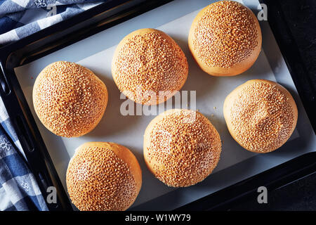Frisch gebackene heißen hausgemachten Burger Brötchen auf das Backblech, von oben betrachten, flatlay, close-up Stockfoto