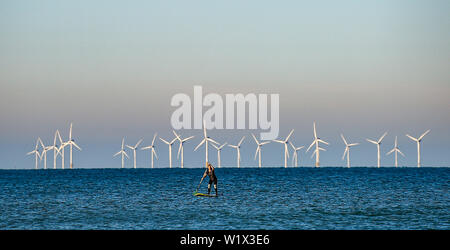 Brighton UK 4. Juli 2019 - ein Paddel boarder geniesst die Sonne am frühen Morgen aus Brighton Beach mit den Rapunzeln Wind Farm hinter in der Ferne. Das Wetter wird prognostiziert einen weiteren sonnigen Tag an der Südküste von Großbritannien mit zu erwartenden Höchsttemperaturen um 27 Grad in einigen Teilen zu erreichen. Foto: Simon Dack/Alamy leben Nachrichten Stockfoto