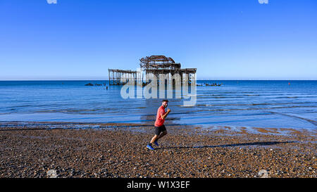 Brighton UK 4. Juli 2019 - ein Läufer genießt am frühen Morgen Sonnenschein am Brighton Beach von der West Pier mit der Wettervorhersage ein anderes heißen, sonnigen Tag an der Südküste von Großbritannien werden mit Temperaturen erwarteten 27 Grad in einigen Teilen zu erreichen. Foto: Simon Dack/Alamy leben Nachrichten Stockfoto