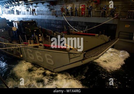 190702-N-DX 072-1003 CORAL SEA (2. Juli 2019) Segler verwenden Sie Leitungen zu führen Landing Craft, Utility (LCU) 1666, zugeordnet zu den Naval Beach (NBU) 7, aus dem Brunnen Deck des amphibious Transport dock Schiff USS Green Bay LPD (20). Green Bay, Teil der Wasp Amphibious Ready Group, mit 31 Marine Expeditionary Unit in Angriff genommen, ist die in der indopazifischen Region Interoperabilität mit Partnern zu verbessern und dienen als ready-Response Force für jede Art von Kontingenz, und stellen gleichzeitig eine flexible und tödliche Krise Response Force bereit, eine breite Palette von militärischen Operationen durchführen. Stockfoto