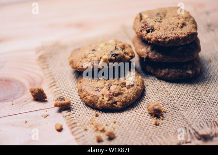 Cookies auf Sack auf Holztisch, Nahaufnahme Stockfoto