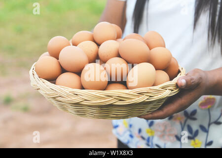 Eier in einem Korb/Frau Bauer Holding Holz- Fach mit frischem huhn eier Sammeln vom Bauernhof auf dem Land Stockfoto
