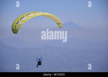 Wonosobo paragliding Fliegen hoch mit Blick auf die Berge Stockfoto