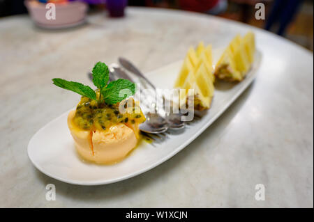 Eis Passionsfrucht Sorbet mit fruchtschnitten auf Platte Stockfoto