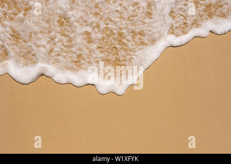 Welle auf dem Sandstrand-Hintergrund Stockfoto