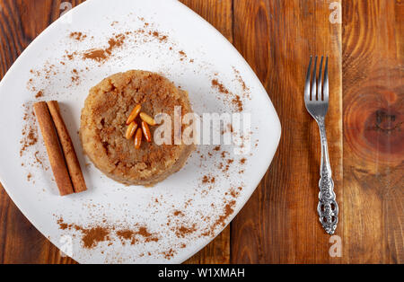 Türkisches Dessert irmik helvasi / griess mit zimtpulver und Erdnuss Stockfoto