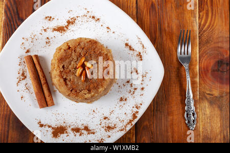 Türkisches Dessert irmik helvasi / griess mit zimtpulver und Erdnuss Stockfoto