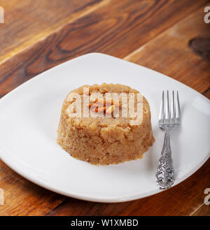Türkisches Dessert irmik helvasi / griess mit zimtpulver und Erdnuss Stockfoto