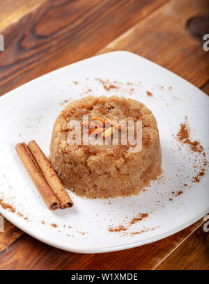 Türkisches Dessert irmik helvasi / griess mit zimtpulver und Erdnuss Stockfoto