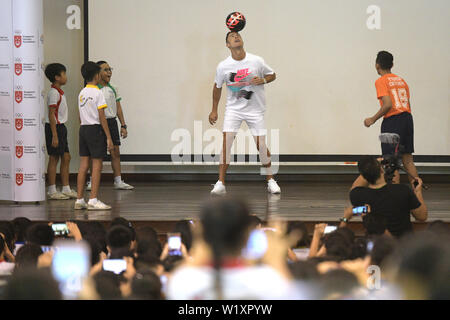 Singapur, Singapur Yumin Primary School. 4. Juli 2019. Portugiesische Fußballspieler Cristiano Ronaldo (L) leitet eine Kugel während einer Aktivität der Singapur olympische Foundation-Peter Lim Gelehrsamkeit, in Singapurs Yumin Grundschule statt, am 4. Juli 2019. Credit: Dann Chih Wey/Xinhua/Alamy leben Nachrichten Stockfoto