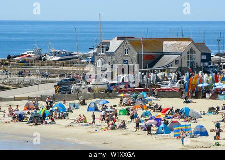 Lyme Regis, Dorset, Großbritannien. 4. Juli 2019. UK Wetter. Sonnenanbeter am Strand an der Küste von Lyme Regis in Dorset genießen ein Tag der klare Himmel und glühend heiße Sonne. Foto: Graham Jagd-/Alamy leben Nachrichten Stockfoto