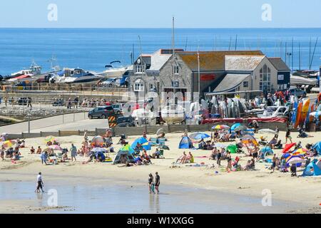 Lyme Regis, Dorset, Großbritannien. 4. Juli 2019. UK Wetter. Sonnenanbeter am Strand an der Küste von Lyme Regis in Dorset genießen ein Tag der klare Himmel und glühend heiße Sonne. Foto: Graham Jagd-/Alamy leben Nachrichten Stockfoto