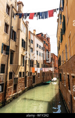 Wäsche waschen Kleidung heraus hängen an Seilen zwischen den Häusern über schmalen Kanal, Venedig, Italien Stockfoto