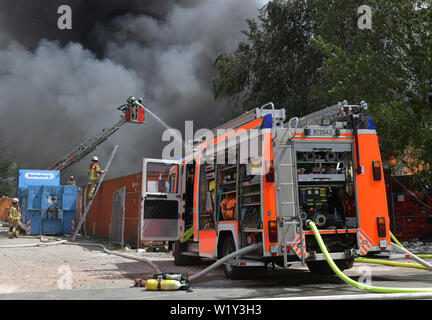 Berlin, Deutschland. 04. Juli, 2019. Feuerwehrmänner sind aktiv bei einem Brand auf dem Gelände eines Einkaufszentrums in Berlin-Lichtenberg. Nach der Berliner Feuerwehr, Dies ist der Dong-Xuan Einkaufszentrum, welches aus mehreren Hallen und Lager. (Zu "Feuer im Lager in Lichtenberg - große Wolke von Rauch über Berlin') Credit: Paul Zinken/dpa/Alamy leben Nachrichten Stockfoto