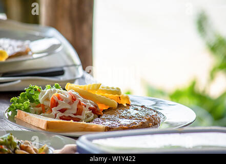 Schweinefleisch Steak mit Pommes Frites und Salat. Stockfoto