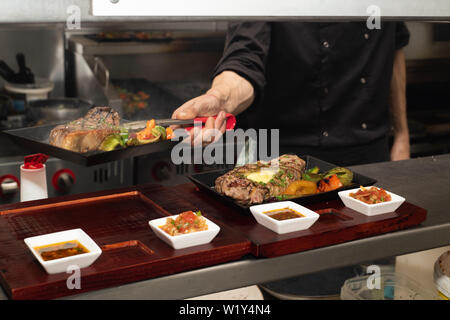 Doncaster, Großbritannien - 11 Mai 2019: Ein Koch an der Arbeit hart kochen und Beschichtung auf einem langen Samstag Nacht Dinner Service 11. Mai in La Boca argentinische Steak ho Stockfoto
