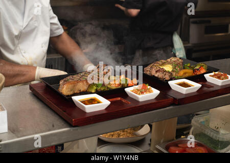 Doncaster, Großbritannien - 11 Mai 2019: Zwei Köche an der Arbeit hart kochen und Beschichtung auf einem langen Samstag Nacht Dinner Service 11. Mai in La Boca argentinische Steak h Stockfoto