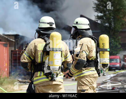 Berlin, Deutschland. 04. Juli, 2019. Feuerwehrmänner sind aktiv bei einem Brand auf dem Gelände eines Einkaufszentrums in Berlin-Lichtenberg. Nach der Berliner Feuerwehr, Dies ist der Dong-Xuan Einkaufszentrum, welches aus mehreren Hallen und Lager. (Zu "Feuer im Lager in Lichtenberg - große Wolke von Rauch über Berlin') Credit: Paul Zinken/dpa/Alamy leben Nachrichten Stockfoto