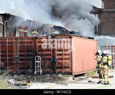 Berlin, Deutschland. 04. Juli, 2019. Feuerwehrmänner sind aktiv bei einem Brand auf dem Gelände eines Einkaufszentrums in Berlin-Lichtenberg. Nach der Berliner Feuerwehr, Dies ist der Dong-Xuan Einkaufszentrum, welches aus mehreren Hallen und Lager. (Zu "Feuer im Lager in Lichtenberg - große Wolke von Rauch über Berlin') Credit: Paul Zinken/dpa/Alamy leben Nachrichten Stockfoto