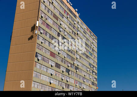 Ein Gebäude in Durban - SÜDAFRIKA - JUNI 2019 mit Satellitenschüsseln auf fast jedem Fenster mit den blauen Himmel hinter sich Stockfoto