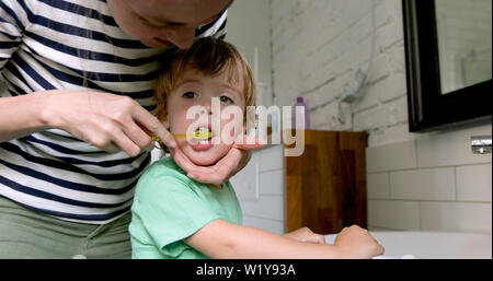 Mutter lehre Sohn seine Zähne putzen Stockfoto