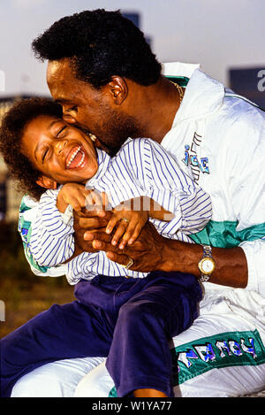 London, 1990. Portrait von Boxer Nigel Benn mit seinem Sohn Dominic. Den Spitznamen der Dunkle Zerstörer, er hielt den WBO-Titel im Mittelgewicht 1990, und den WBC Stockfoto