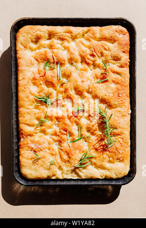 Italienische Focaccia, Ansicht von oben mit rosa Salz und Olivenöl, Ansicht von oben Zusammensetzung, mit direkten starkes Licht und Schatten, bei einem leichten Braun zurück Stockfoto