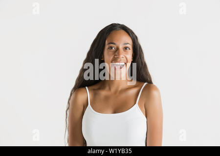 Schöne weibliche Brustbild auf weißem studio Hintergrund isoliert. Junge emotionale Afrikanisch-amerikanische Frau mit langen Haaren. Mimik, menschliche Emotionen Konzept. Erstaunt, begeistert. Stockfoto