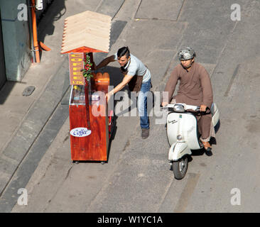 SAIGON, VIETNAM, Dec 13 2017, ein buddhistischer Mönch auf einem Roller Fahrten um ein Mann drücken Coffee shop Stall. Das Leben auf den Straßen von Saigon Stadt. Stockfoto