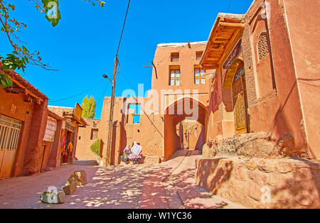 ABYANEH, IRAN - Oktober 23, 2018: zwei Abyanaki Frauen in traditioneller Kleidung sprechen in Dorf Straße neben dem touristischen Store, am 23. Oktober in Abyaneh Stockfoto