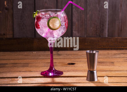 Pink Gin Tonic mit Himbeeren, Holz- Hintergrund Stockfoto