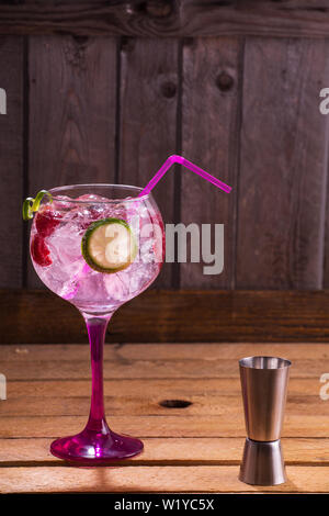 Pink Gin Tonic mit Himbeeren, Holz- Hintergrund Stockfoto