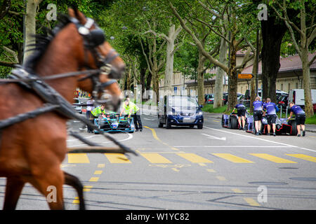 Ein Pferd caddy Geschwindigkeiten Vergangenheit, während Mitglieder der Besatzung eines der HWA Formel E Autos aus der Boxengasse wieder zurück in die Garage vor der ABB FIA Formel E Rennen in Bern. Stockfoto