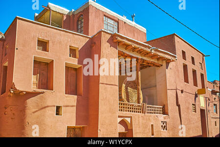 Die Fassade der alten Moschee von Abyaneh Dorf mit roten Adobe Wände und die nakhl Holz- struktur für Ashura Ritual, stehend auf der Terrasse, im Iran. Stockfoto