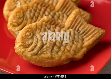 Frisch gebackene Taiyaki, japanischen Fisch geformten Kuchen mit roten Bohnen paste schließen gefüllt. Stockfoto