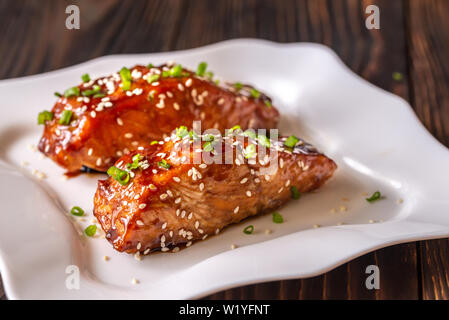 Zwei Stücke von teriyaki Lachs garniert mit Sesam und Frühlingszwiebel Stockfoto