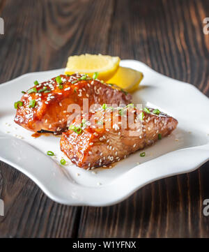 Zwei Stücke von teriyaki Lachs garniert mit Sesam und Frühlingszwiebel Stockfoto