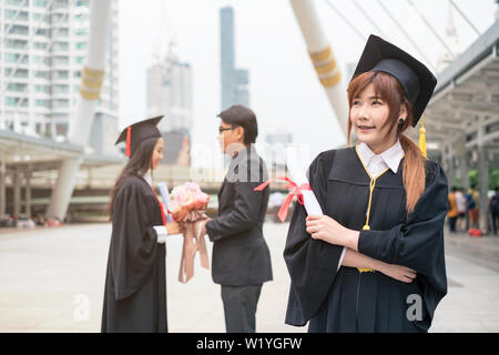 Woman's Absolvent Bachelor, Diplom mit ein paar Herzlichen Glückwunsch Hintergrund Stockfoto