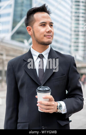 Smart Bart Geschäftsmann in Anzug und Krawatte, die Tasse Kaffee in der Stadt - selektive Fokus Stockfoto