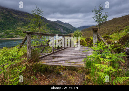 Die alte Holzbrücke auf dem Fußweg zu Barisdale in Knoydart in den schottischen Highlands nur zu Fuß oder mit dem Boot zu erreichen ist es sehr abgelegenen Wildnis Stockfoto