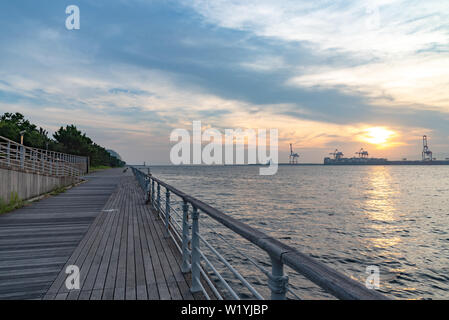 Osaka Bay mit Yumeshima Insel auf Hintergrund im Sommer sun set time, Ansicht von Osaka metro Cosmosquare Bahnhof Park Promenade Stockfoto