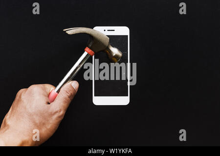 Männliche hand mit einem Hammer auf gehärtetem Glas Schild oder Filmfolien. Handy protector Konzepte Ideen Stockfoto