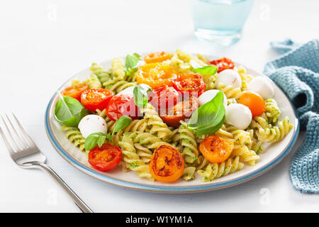 Gesunde Fusilli mit Pesto, gebratenen Tomaten, Mozzarella Stockfoto