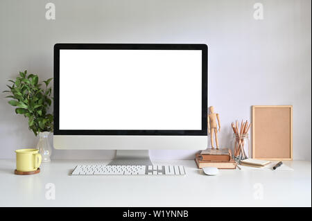 PC Computer auf Arbeitsbereich mit Kaffeetasse, Bleistift, Bücher und Werk auf Büro Schreibtisch. Stockfoto