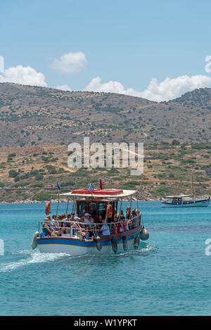 Kreta, Griechenland. Juni 2019. Kleine Passagier Schiff mit Touristen unterwegs auf den Golf von Mirabello aus der Cret Küste. Stockfoto