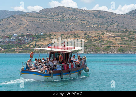 Kreta, Griechenland. Juni 2019. Kleine Passagier Schiff mit Touristen unterwegs auf den Golf von Mirabello aus der Cret Küste. Stockfoto