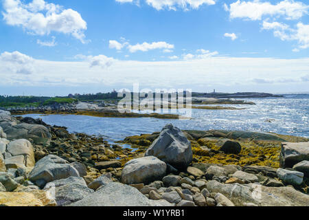 Blick auf einem felsigen Ufer mit Peggys Cove im Hintergrund, Nova Scotia, Kanada Stockfoto