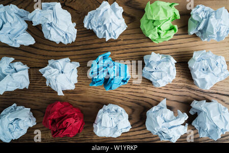 Papier symbolisieren unterschiedliche Lösungen mit einigen ständigen heraus mit einer anderen Farbe zerknittert Stockfoto