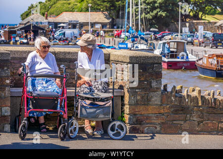 Bude, North Cornwall, England. 4. Juli 2019. UK Wetter. Da die Temperaturen im Süden von England, zwei Damen sitzen und genießen Sie ein Schwätzchen in der Sonne, in der Stadt in der malerischen Brücke Bude in North Cornwall. Stockfoto